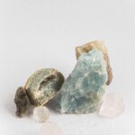 A collection of various healing crystals and stones arranged on a white background, showcasing their natural beauty.